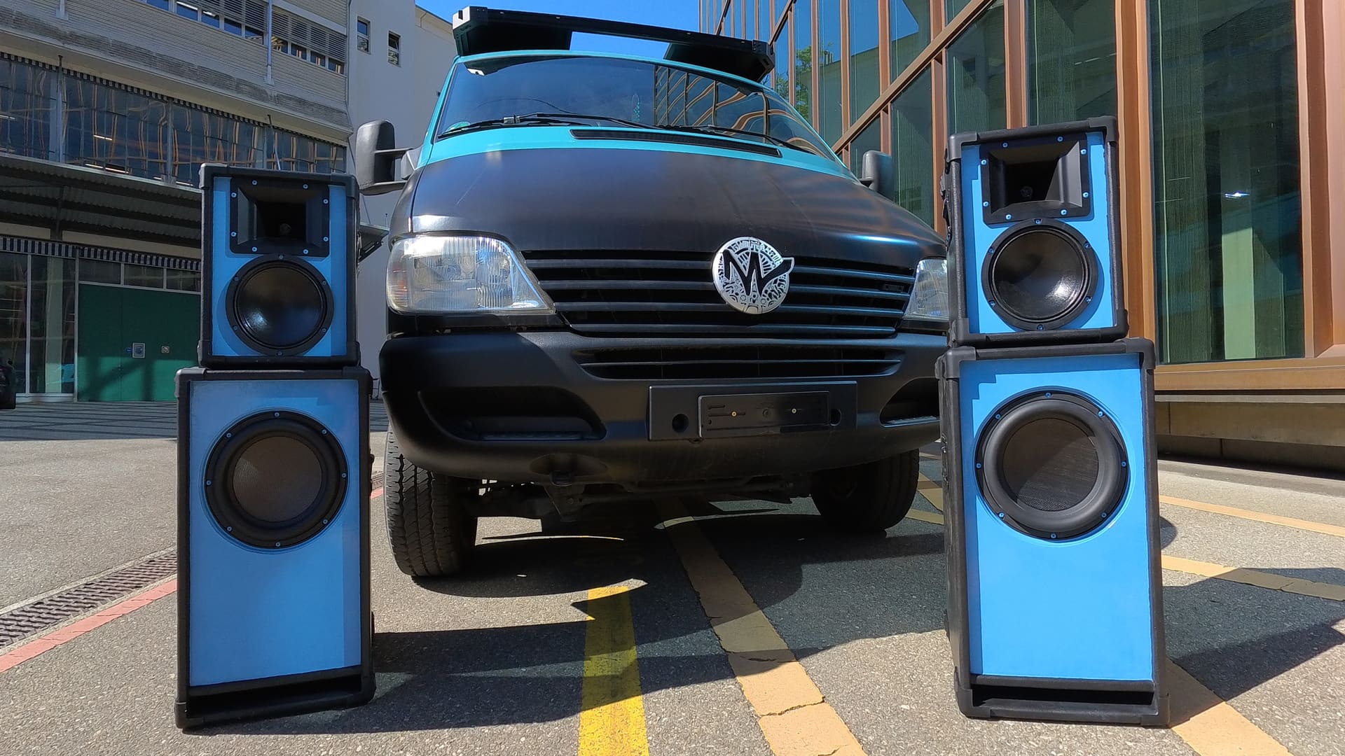 Der bass.cruiser frontal mit vier türkis-schwarzen Boxentürmen davor